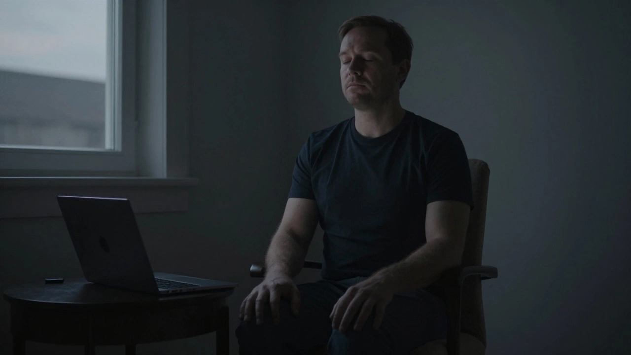 Мужчина сидит в темной комнате с закрытыми глазами, спокойно дышит, избегая экранов перед сном.